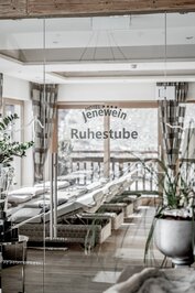 Blick durch eine Glastür in den Ruheraum mit Liegen im Hotel Jenewein.