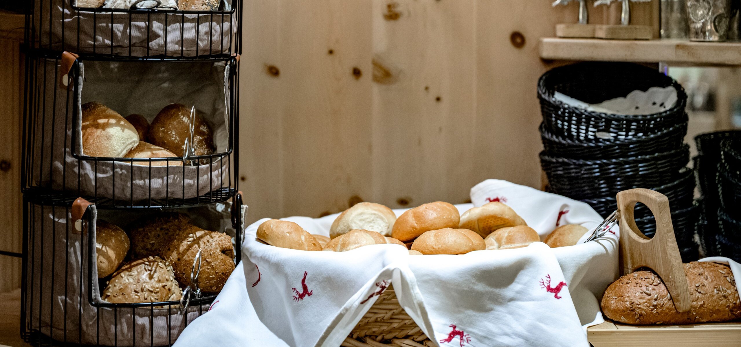 Frische Brötchen und Brote stehen in Körben beim Frühstücksbuffet.