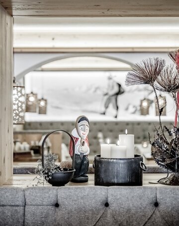 Dekorative Tischdekoration mit Kerzen und einer Figur in der Hexenkuchl im Hotel Jenewein.