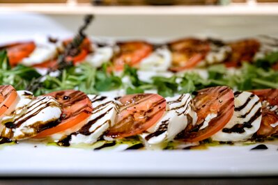 Tomaten- und Mozzarellascheiben mit Balsamico auf einem Teller im Hotelrestaurant.