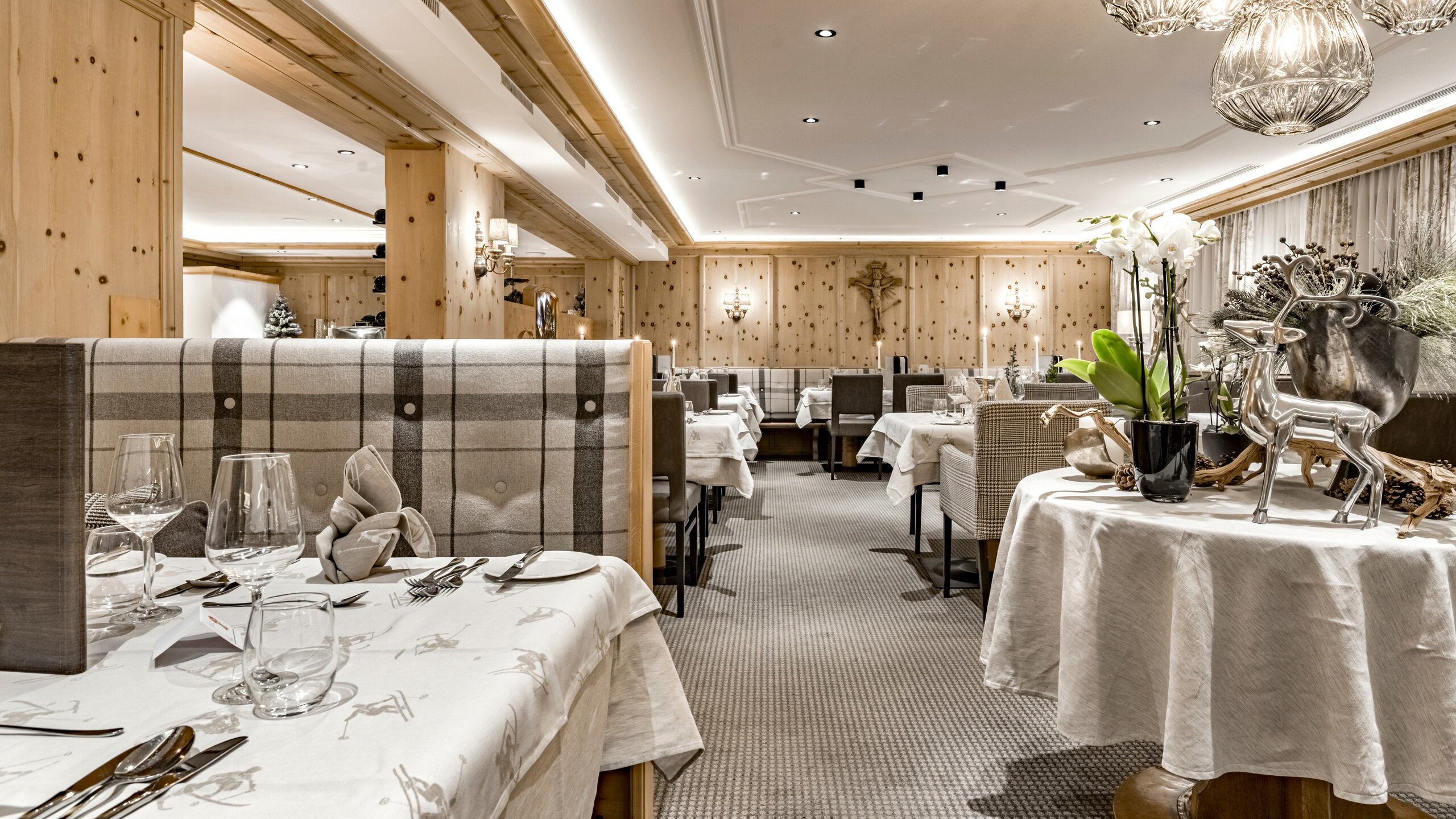 Ein stilvoll gedecktes Hotelrestaurant mit Holzelementen, gedeckten Tischen und dekorativen Details.