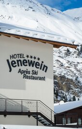 Das Hotelschild Jenewein steht vor verschneiten Bergen in Obergurgl.