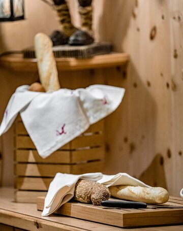 Frisch angerichtete Brote auf einer Holzablage im Hotelrestaurant.