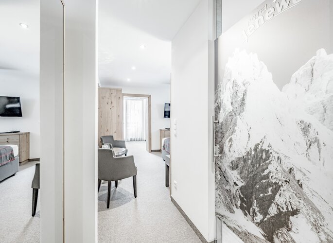 Familienzimmer Süd im Hotel Jenewein Heller Blick in ein Familienzimmer mit Sitzbereich und zwei Betten im Hotel Jenewein.