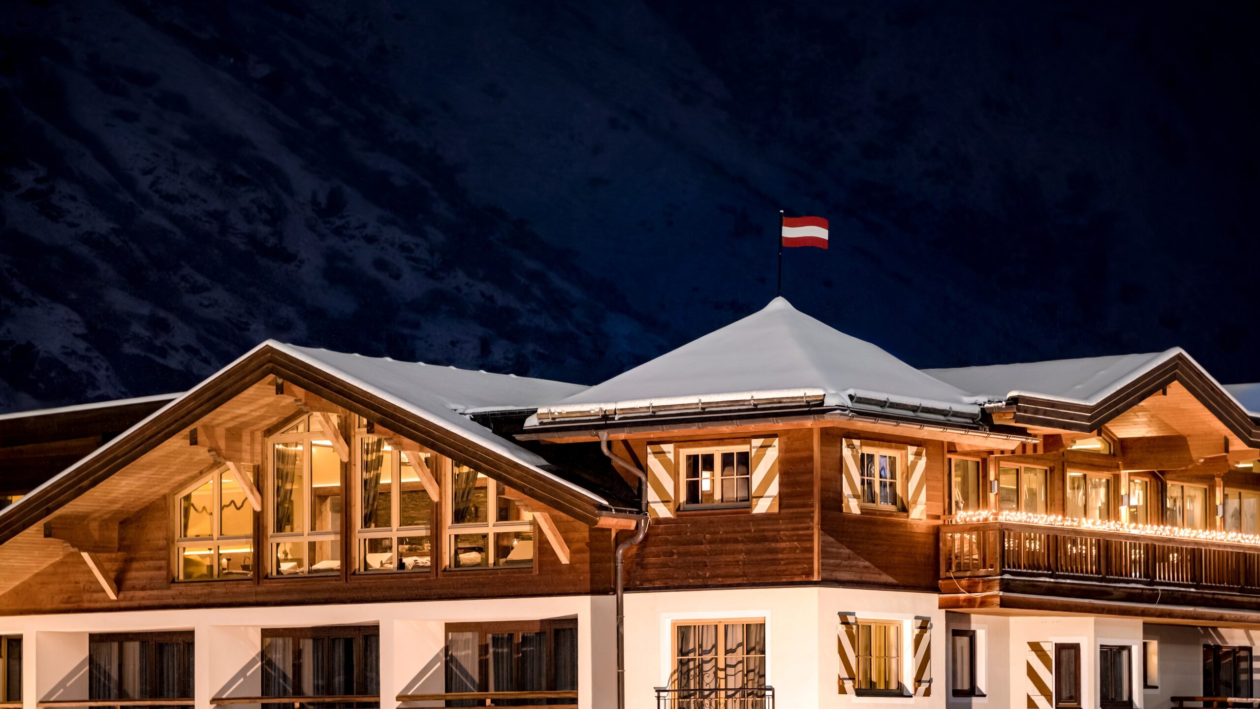 Das Hotel Jenewein in Obergurgl steht mit beleuchteten Fenstern unter einer verschneiten Dachlandschaft.