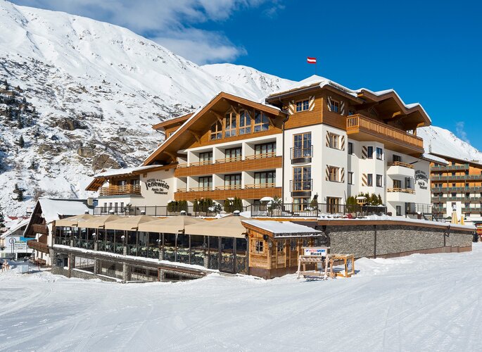 Das Hotel Jenewein liegt im Schnee vor einem steilen Bergpanorama in Obergurgl.