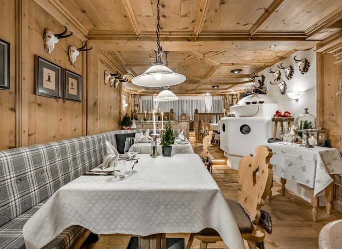 Ein gemütlich gedeckter Tisch im Hotelrestaurant mit Holzausstattung und regionalem Ambiente.