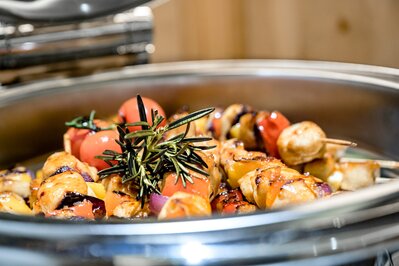 Gegrilltes Gemüse mit Kräutern in einer warmen Servierschale im Hotelrestaurant.
