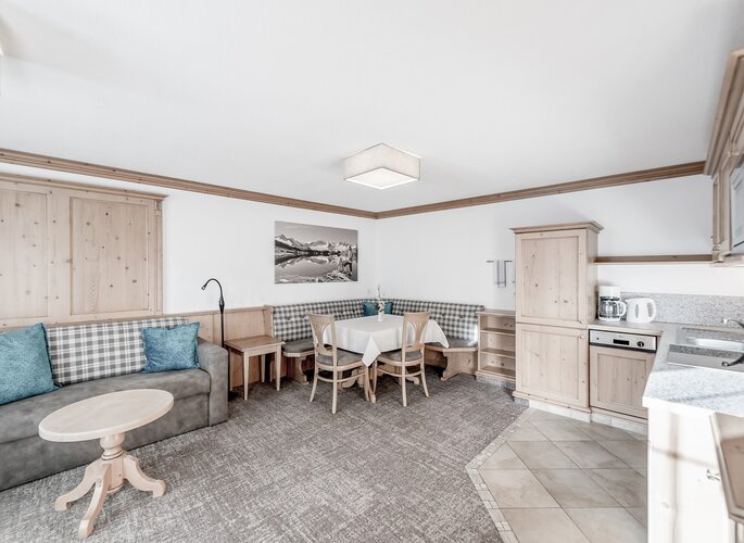 Familienappartement mit Essecke im Landhaus Jenewein Gemütlicher Wohn- und Essbereich im Familienappartement mit Eckbank, Sofa und Küchenzeile.