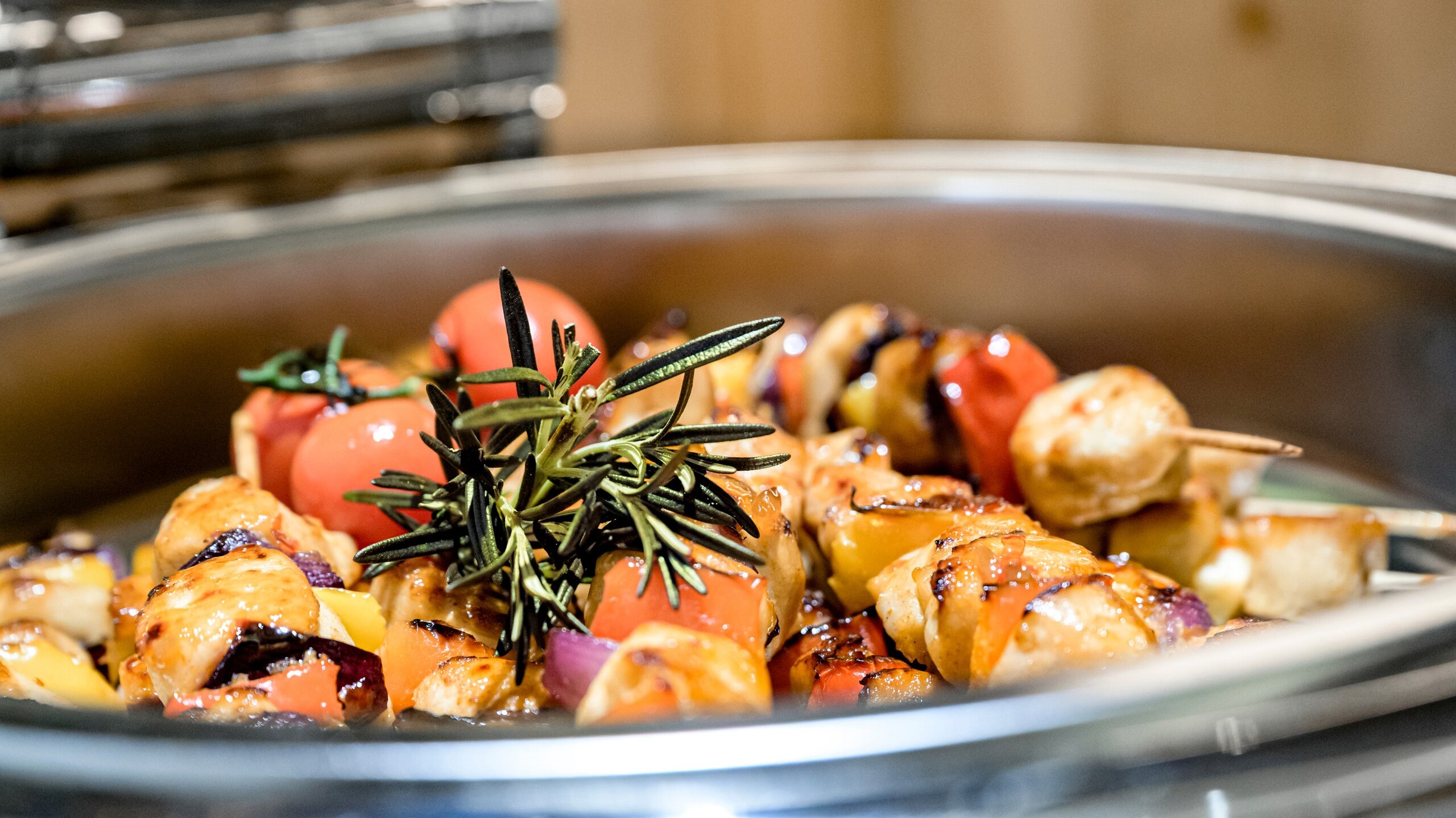 Grillgemüse mit Rosmarin und Cherrytomaten in einer Servierschale im Hotelrestaurant.