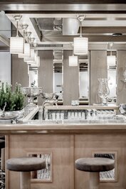Eine elegante Hotelbar mit Zapfhahn, Gläsern und hängenden Leuchten.