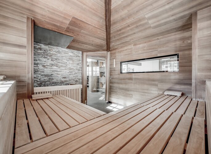 Innenansicht einer Sauna mit Holzverkleidung und Sitzbänken im Wellnessbereich des Hotel Jenewein in Obergurgl.