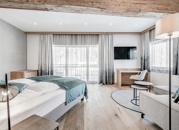 Komfortzimmer im Hotel Jenewein in Obergurgl Helles Komfortzimmer mit Bett, Sitzecke und großem Fenster im Hotel Jenewein in Obergurgl.