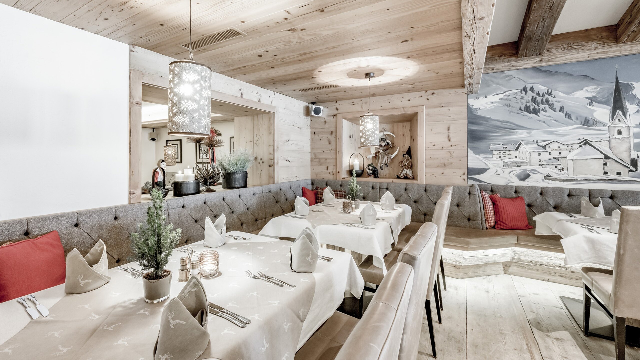 Ein gemütlich eingerichteter Restaurantbereich mit gedeckten Tischen und alpiner Wanddekoration.