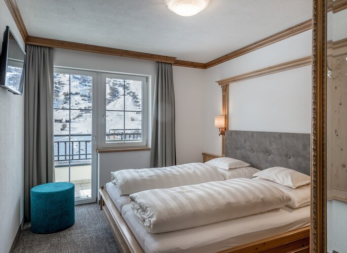 Appartement mit Balkon und Bergblick in Obergurgl Ein helles Schlafzimmer im Appartement mit Doppelbett und Balkonblick auf die verschneite Berglandschaft.