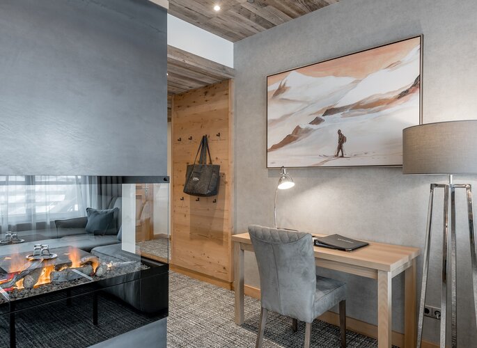 Romantikzimmer im Hotel Jenewein in Obergurgl Ein stilvoll eingerichtetes Romantikzimmer mit Kamin, Schreibtisch und Sitzecke im Hotel Jenewein.