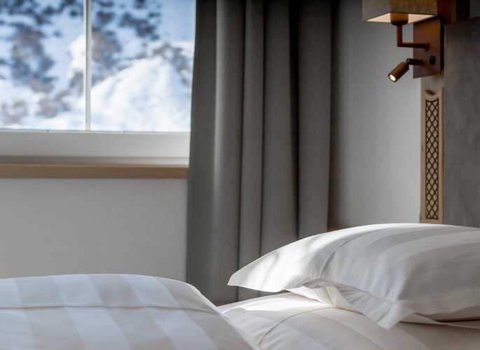 Appartement Obergurgl: Schlafzimmer mit Bergblick Ein Schlafzimmer im Appartement mit weißen Betten und Blick auf die verschneite Berglandschaft.