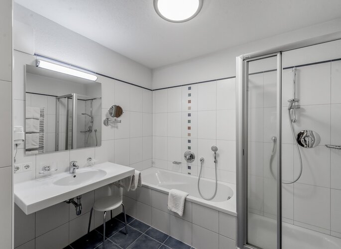 Badezimmer im Appartement in Obergurgl Modernes Badezimmer mit Badewanne, Dusche und Waschtisch im Appartement.