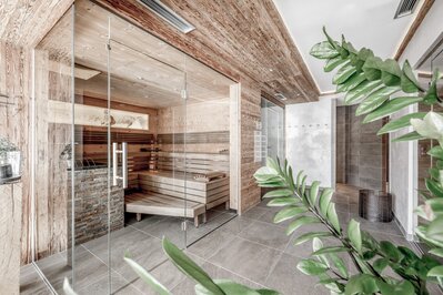 Eine moderne Sauna mit Holzverkleidung und Glasfront im Wellnessbereich.