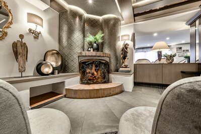 Eine stilvoll eingerichtete Lounge mit Kamin, dekorativen Lampen und Sitzbereich im Hotel Jenewein.
