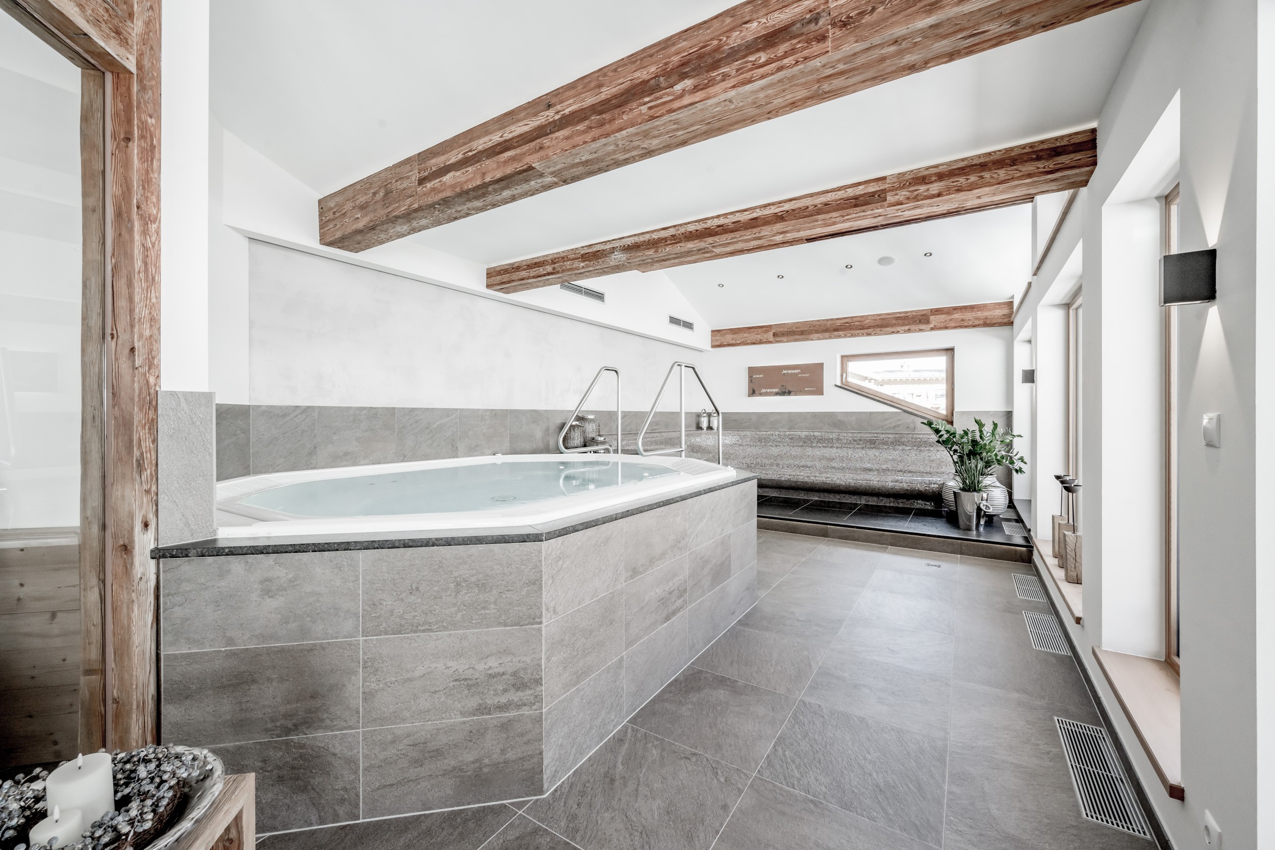 Ein heller Wellnessbereich mit Whirlpool, Saunabereich und Ruheliegen im Hotel Jenewein.